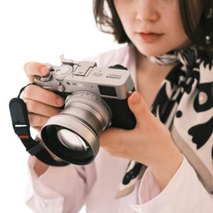 Close-up of a woman holding a digital camera, focusing on the device.