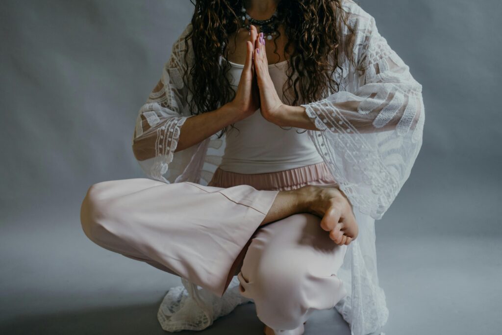 A woman in yoga pose meditating indoors, focusing on relaxation and mindfulness.